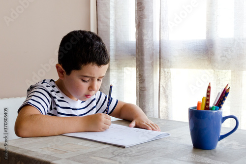 Tableau sur toile Chico joven escribiendo mientras aprende en casa