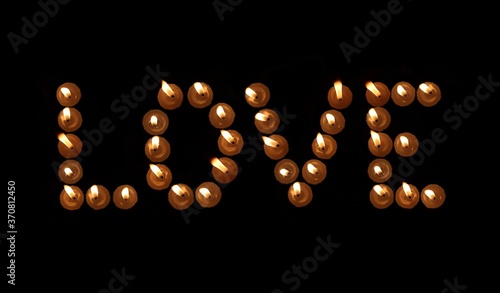 Love Word Written With Burning Candles in Black Background, Perfect for Wallpaper
