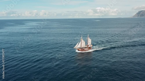 Old pirate ship sailing in the open ocean photo