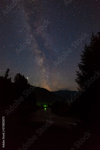 Milky Way over a river and mountains in the Alps