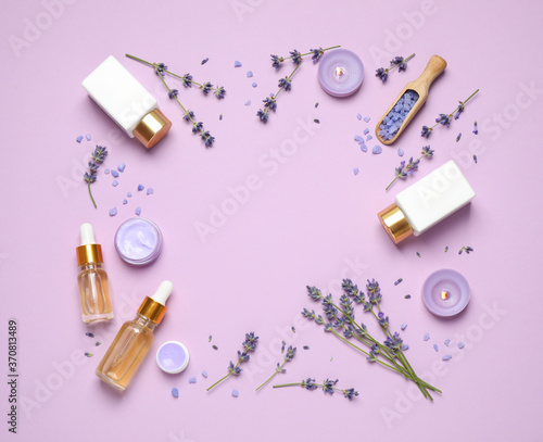Frame made with lavender flowers and natural cosmetic products on pink background. Space for text