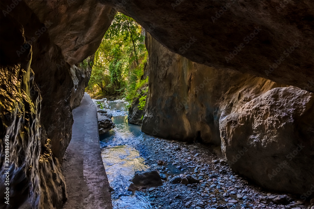 The Monachil river flows through a tunnel in the Sierra Nevada mountains, Spain in the summertime