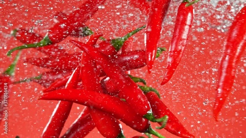 Super Slow Motion Shot of Flying Red Chilli Peppers, Collision in the Air at 1000fps. photo