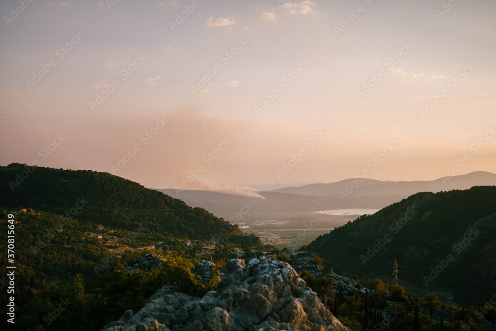A column of smoke on the Lustica Peninsula in Montenegro. Wildfires rage at sunset.