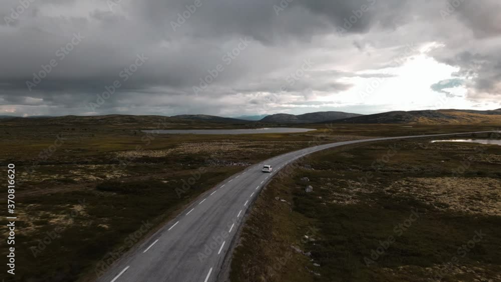 Drone following car with dark skies in the distance. Drone following car with dark skies in the distance.