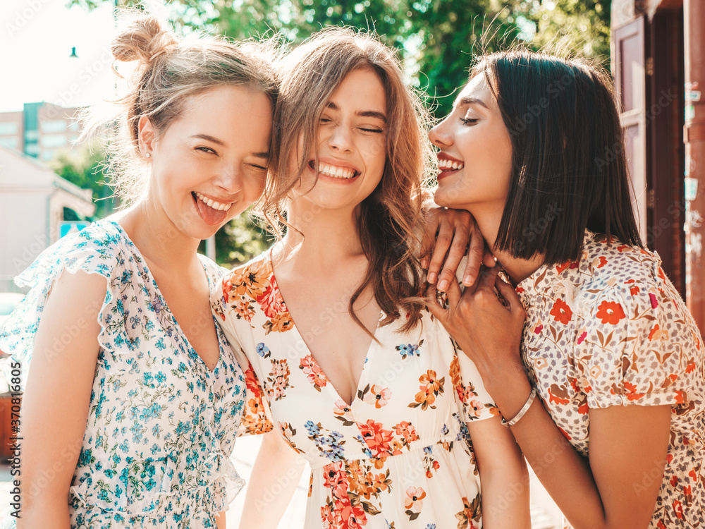 Three young beautiful smiling hipster girls in trendy summer sundress.Sexy carefree women posing on the street background.Models having fun and hugging.Discussing and walking after shopping Three young beautiful smiling hipster girls in trendy summer sundress.Sexy carefree women posing on the street background.Models having fun and hugging.Discussing and walking after shopping