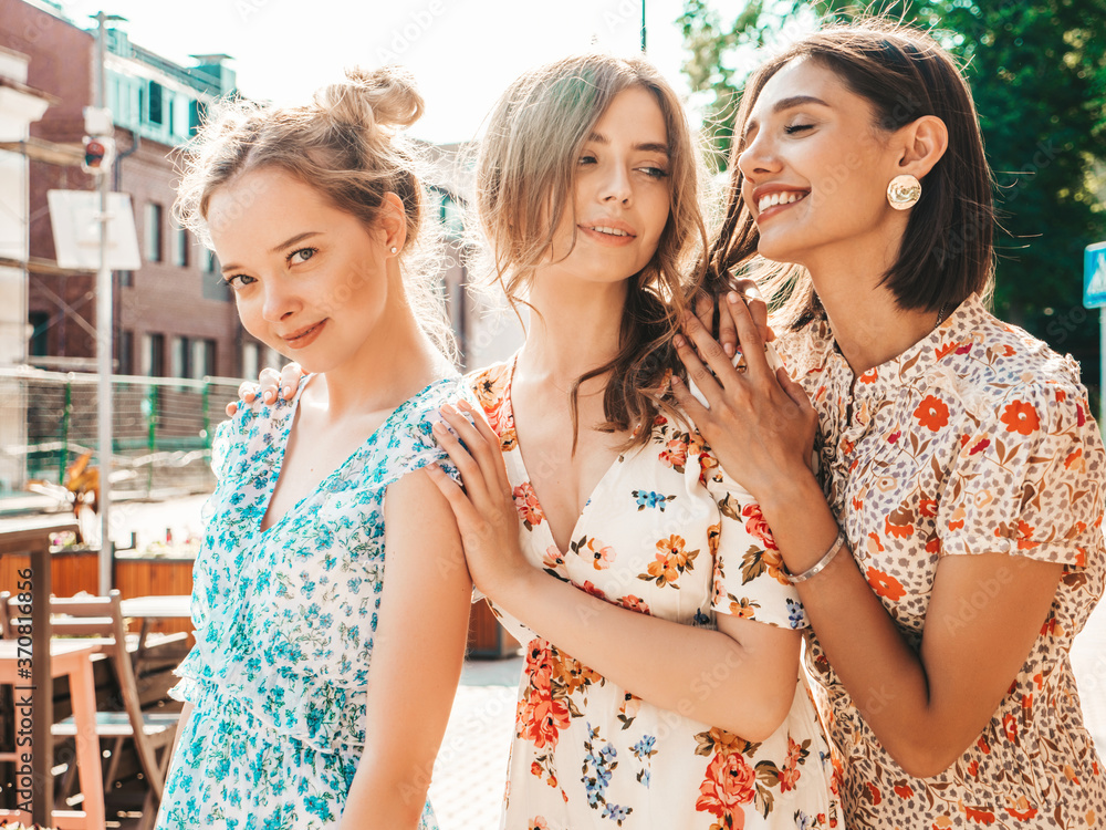 Three young beautiful smiling hipster girls in trendy summer sundress.Sexy carefree women posing on the street background.Models having fun and hugging.Discussing and walking after shopping Three young beautiful smiling hipster girls in trendy summer sundress.Sexy carefree women posing on the street background.Models having fun and hugging.Discussing and walking after shopping