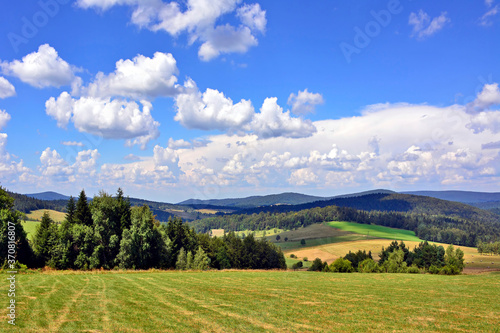 Summer landscape in the mountains with green meadows and forested hills, Low Beskids (Beskid Niski), Poland 