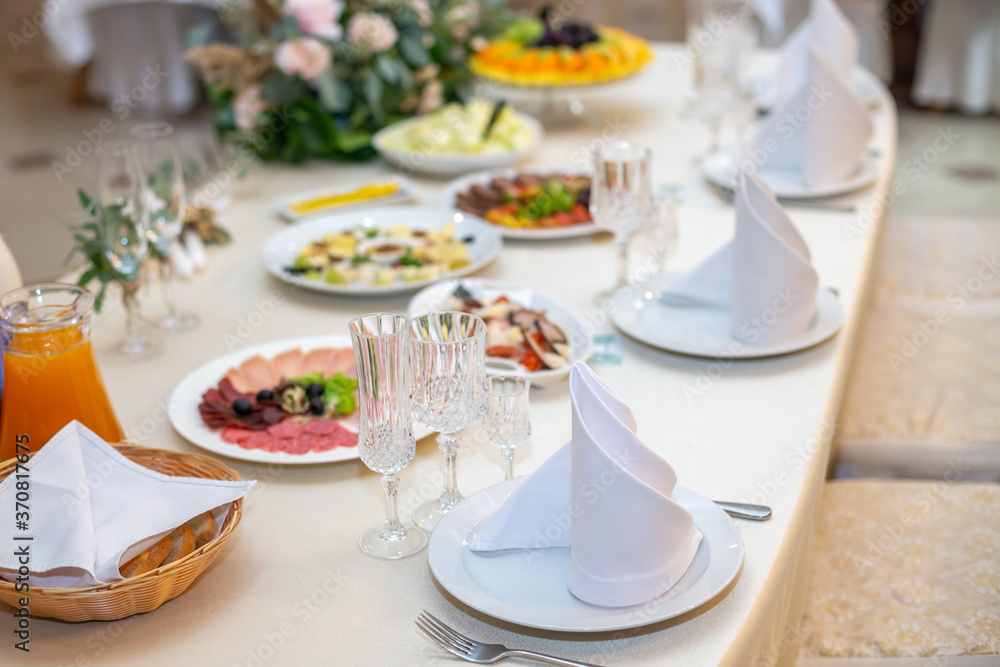 Tasty dishes on a served white banquet table in a luxury restaurant.