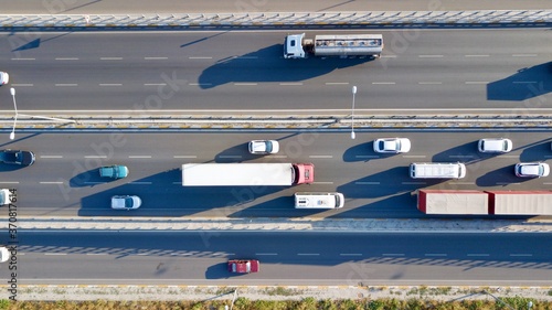 Aerial view of a two-lane expressway or two-lane  bridge freeway at the sunset. Vehicles and commercial trucks can be seen.