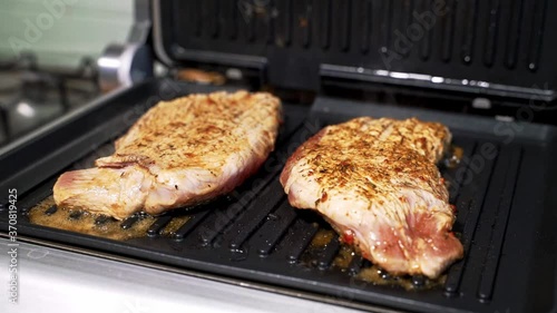 the juicy meat on the grill has just been laid out and it is being fried
