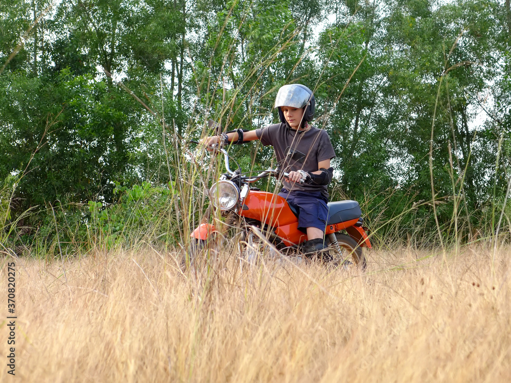 Obraz premium Teen learning to ride on motorcycle 2