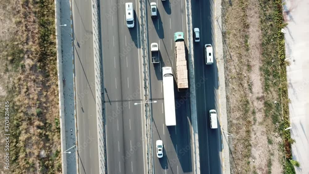 Aerial view of a two-lane expressway or two-lane bridge freeway at the sunset. Vehicles and commercial trucks can be seen. Aerial view of a two-lane expressway or two-lane bridge freeway at the sunset. Vehicles and commercial trucks can be seen.