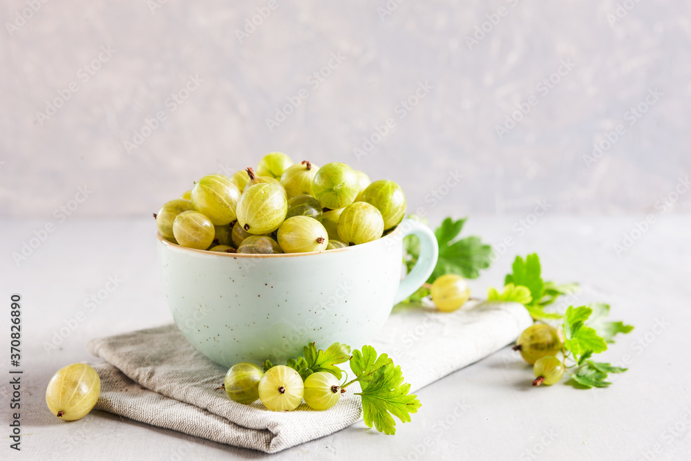 Closeup of Fresh green gooseberries berries with leaves in a cup. Closeup of Fresh green gooseberries berries with leaves in a cup.