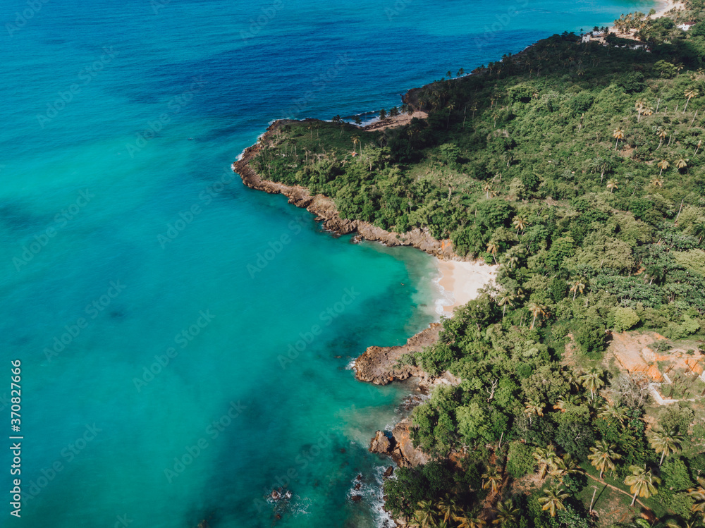Aerial drone view of rocky shore of the Atlantic ocean with blue water lagoon in Las Galeras, Samana, Dominican Republic 