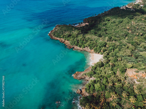 Aerial drone view of rocky shore of the Atlantic ocean with blue water lagoon in Las Galeras, Samana, Dominican Republic 