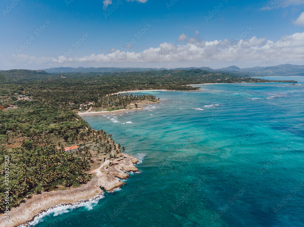 Fototapeta premium Aerial drone view of rocky shore of the Atlantic ocean with blue water lagoon in Las Galeras, Samana, Dominican Republic 