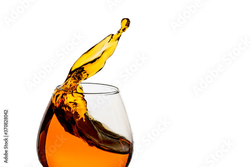 Freeze Action Photography .Splash of Cognac In glass Isolated on White.