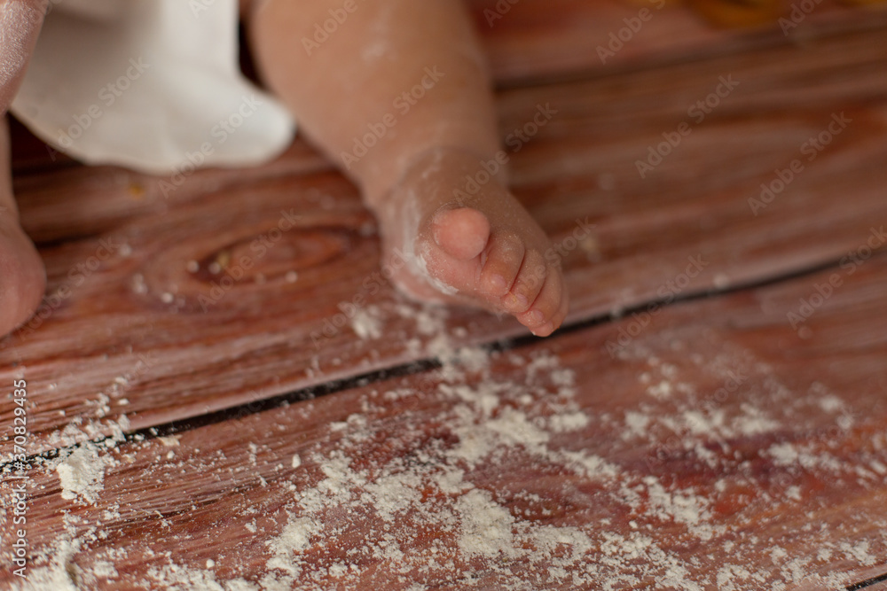 small children's feet in flour on a wooden background small children's feet in flour on a wooden background