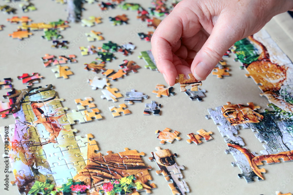 Hand doing a jigsaw puzzle Hand doing a jigsaw puzzle
