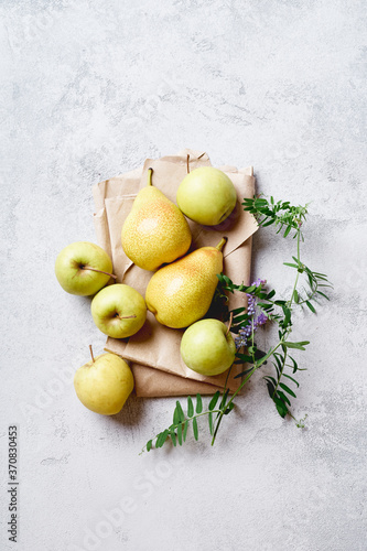 Fresh apples and pears with wild flowers viewed from above photo