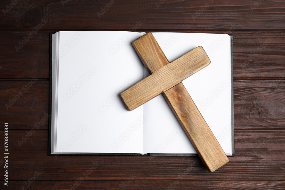 Christian cross and Bible on wooden background, top view. Religion concept