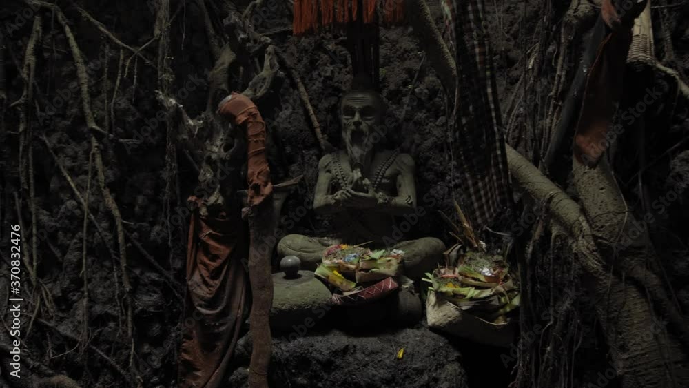 Religious place for rites with ancient statues of people in a dark cave with strong shadows Religious place for rites with ancient statues of people in a dark cave with strong shadows