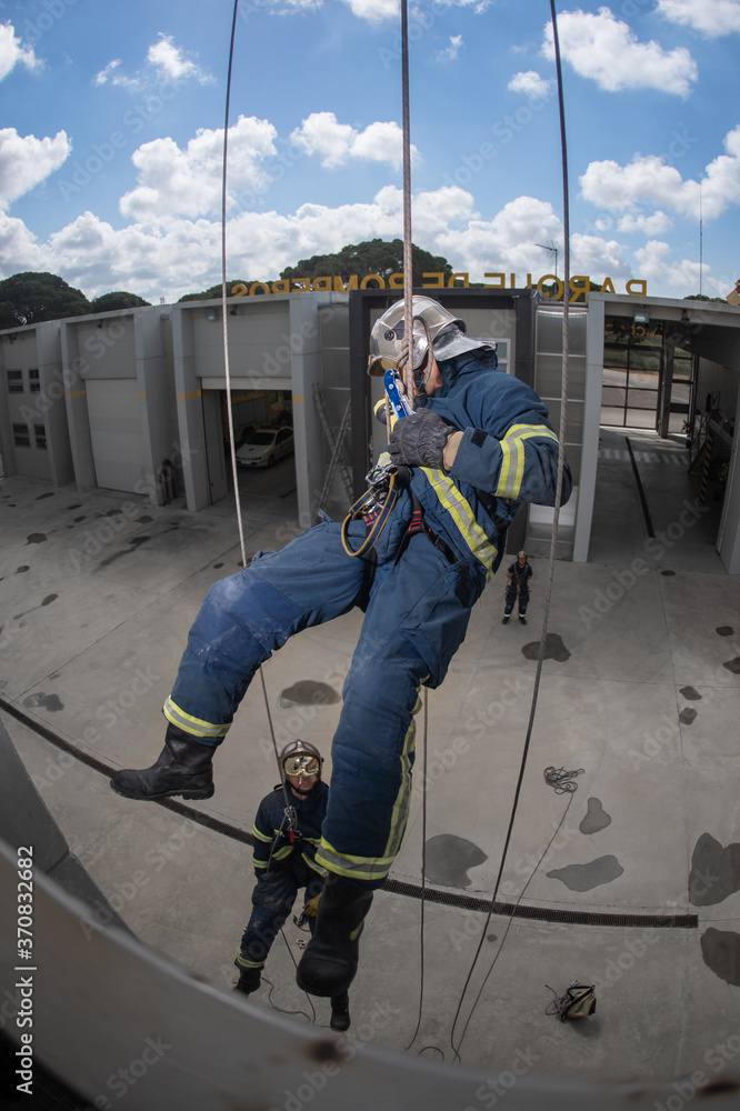 From above of rescue team of firemen standing in spacious complex and preparing for workout with ropes From above of rescue team of firemen standing in spacious complex and preparing for workout with ropes