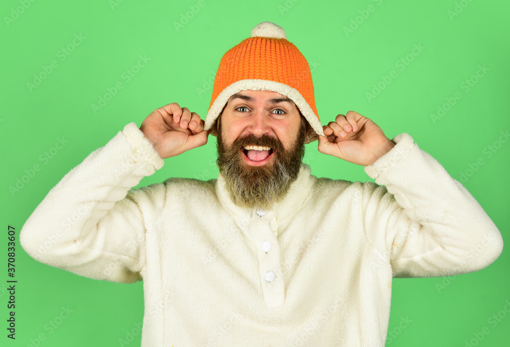 Fototapeta premium Feeling good. Bearded hipster. Hipster style. Head in warm hat. Handsome man knitted hat with pom pom. Fashion concept. Winter clothes and accessories. Mature emotional hipster funny style accessory