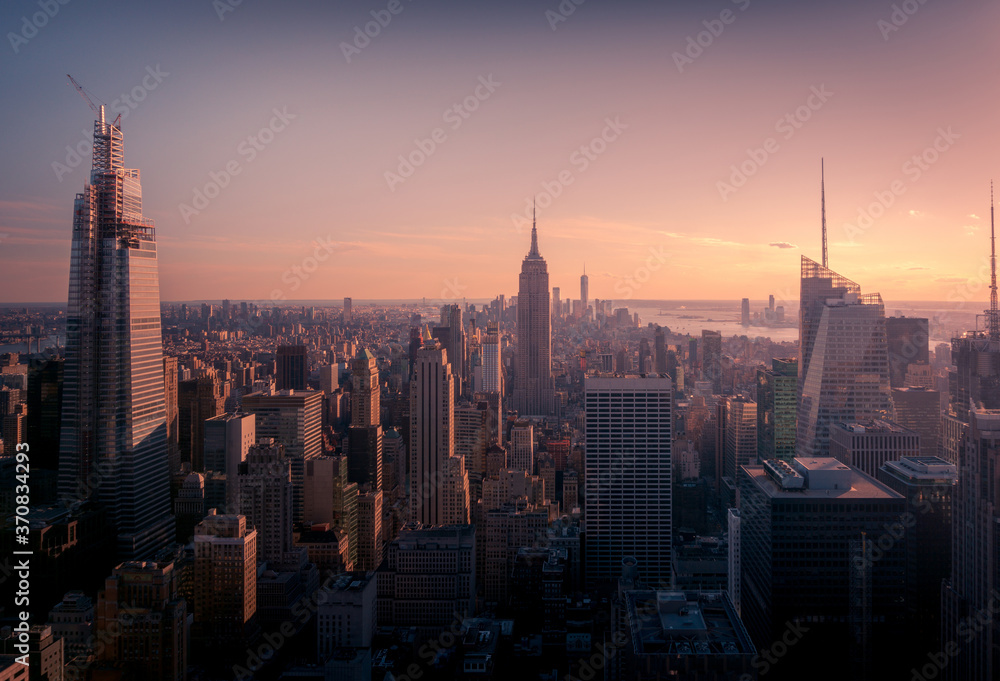 Amazing view of Manhattan district with contemporary buildings and towers seen from high viewpoint against colorful sunset sky Amazing view of Manhattan district with contemporary buildings and towers seen from high viewpoint against colorful sunset sky