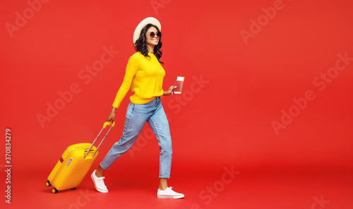 Ethnic traveler walking with suitcase. photo