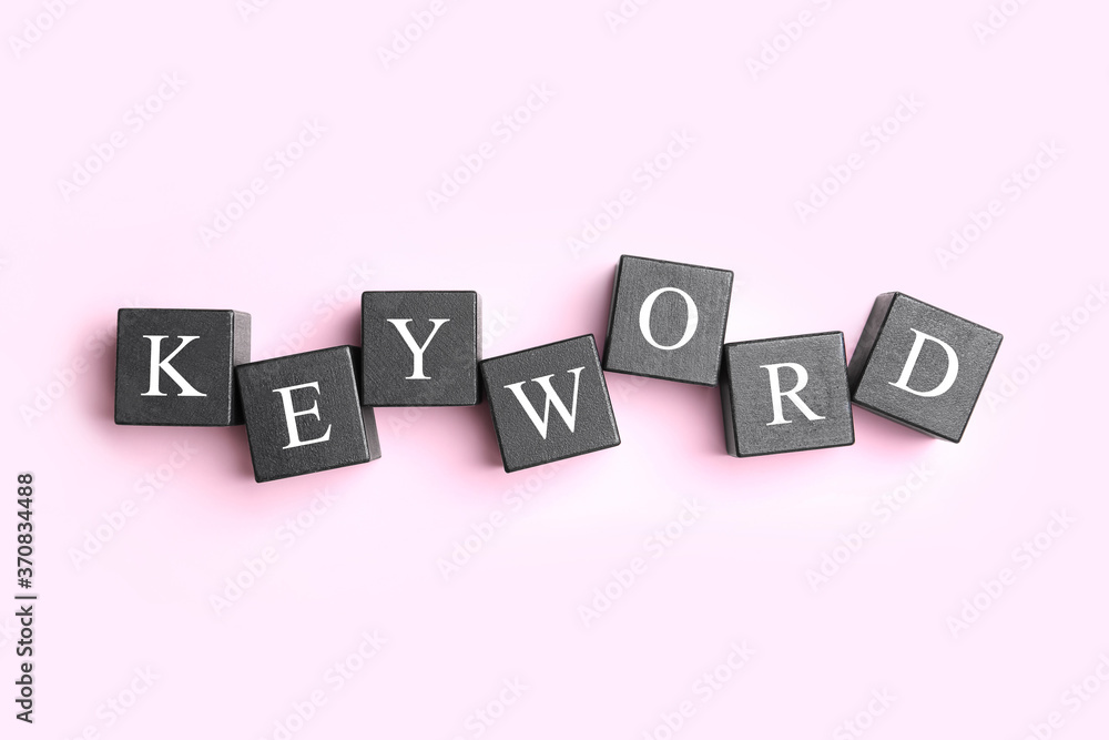 Black cubes with word KEYWORD on pink background, flat lay Black cubes with word KEYWORD on pink background, flat lay