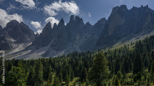 On trekking trail to Malga Brogles refuge with the view of Puez-Odle mountain group needle-shaped peaks ahead, Puez-Odle Nature park, Dolomites, South Tirol, Italy.