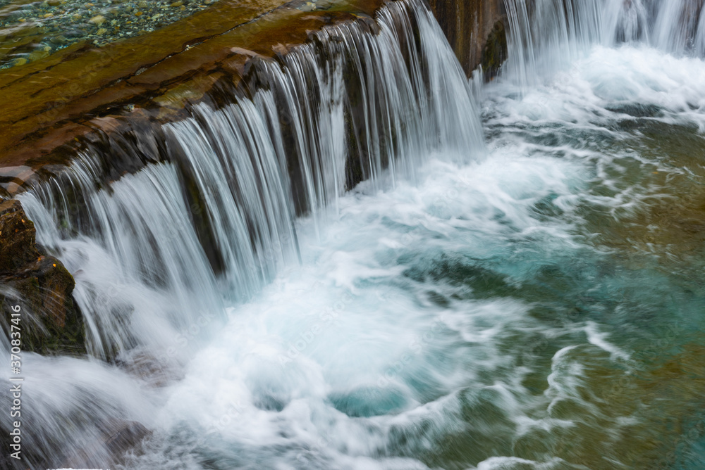 Picturesque scenery of rapid river with wide waterfall and rocky pool Picturesque scenery of rapid river with wide waterfall and rocky pool