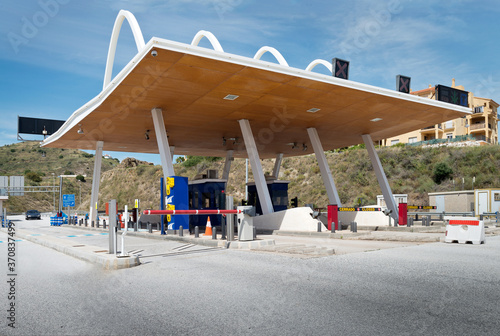 Futuristic exterior of toll road with contemporary payment system on background of blue sky