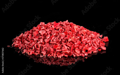 Pile of polypropylene pellets placed on shiny table on black background in studio photo