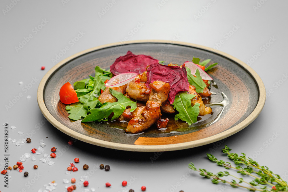 Grilled grilled meat in sauce with vegetables on a white plate. Grilled grilled meat in sauce with vegetables on a white plate.