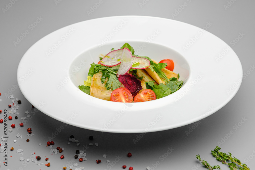 Squid with vegetables, tomatoes, salad and radishes on a white plate. Squid with vegetables, tomatoes, salad and radishes on a white plate.