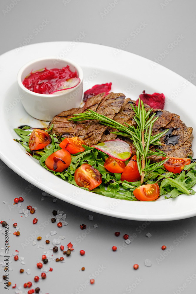 Grilled maso with vegetables and rosemary on a white plate. Grilled maso with vegetables and rosemary on a white plate.