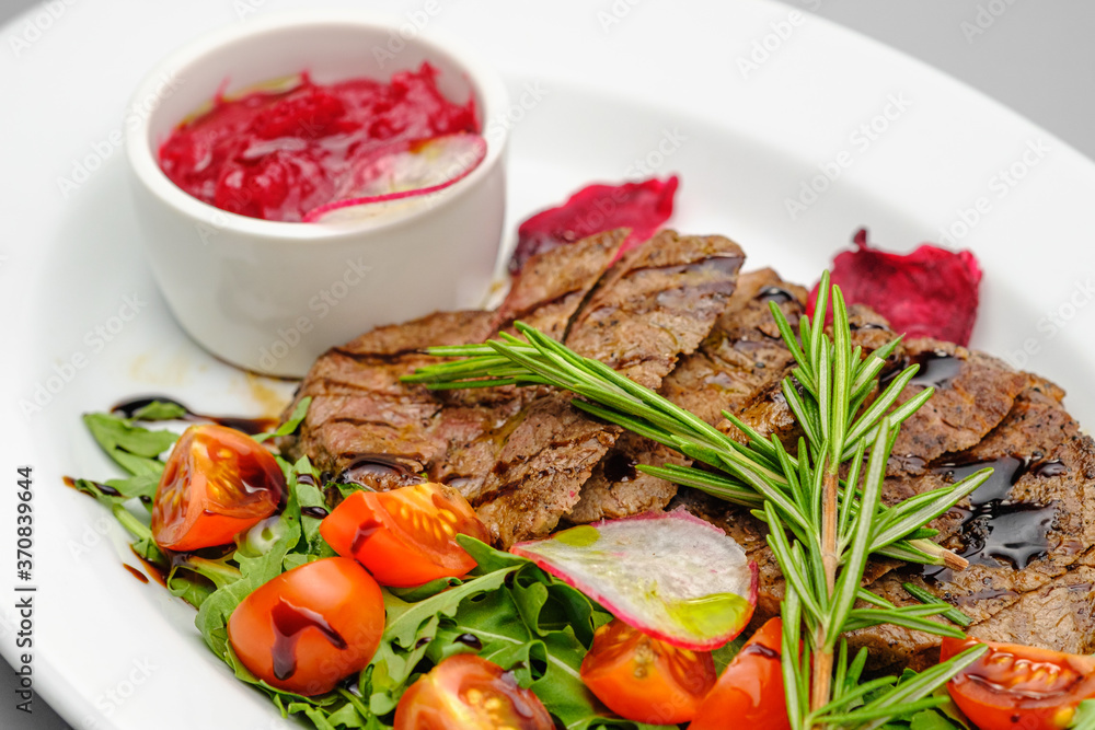 Grilled maso with vegetables and rosemary on a white plate. Grilled maso with vegetables and rosemary on a white plate.