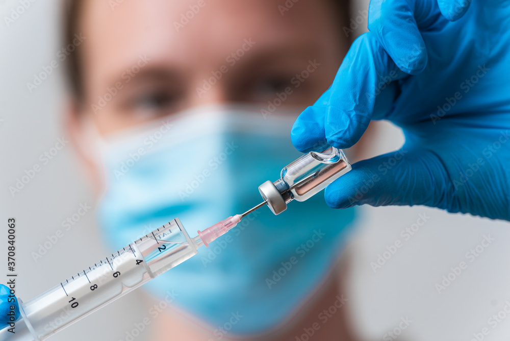A corona-virus vaccine in the hand of a medical worker, COVID-19 vaccine, cure for the virus A corona-virus vaccine in the hand of a medical worker, COVID-19 vaccine, cure for the virus