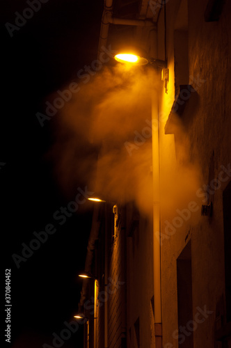 Illuminated street lights in the fog at night. Sabiñanigo. Huesca. Aragon. Spain. photo