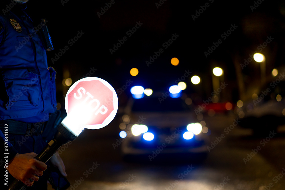 Stop Sign Cop Side view of crop policeman wearing uniform with illuminated stop sign ...