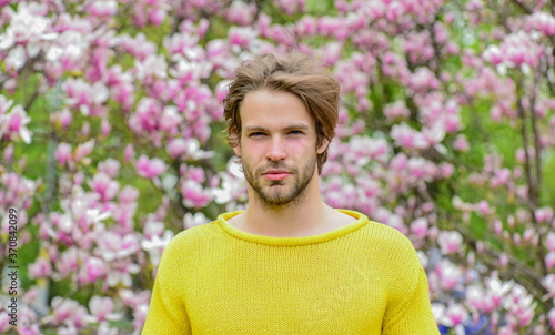 It is spring time. unshaven man magnolia tree. fresh blossom flower. sakura background. enjoy good weather. sexy guy blooming flower tree. spring fashion style. Male sexuality