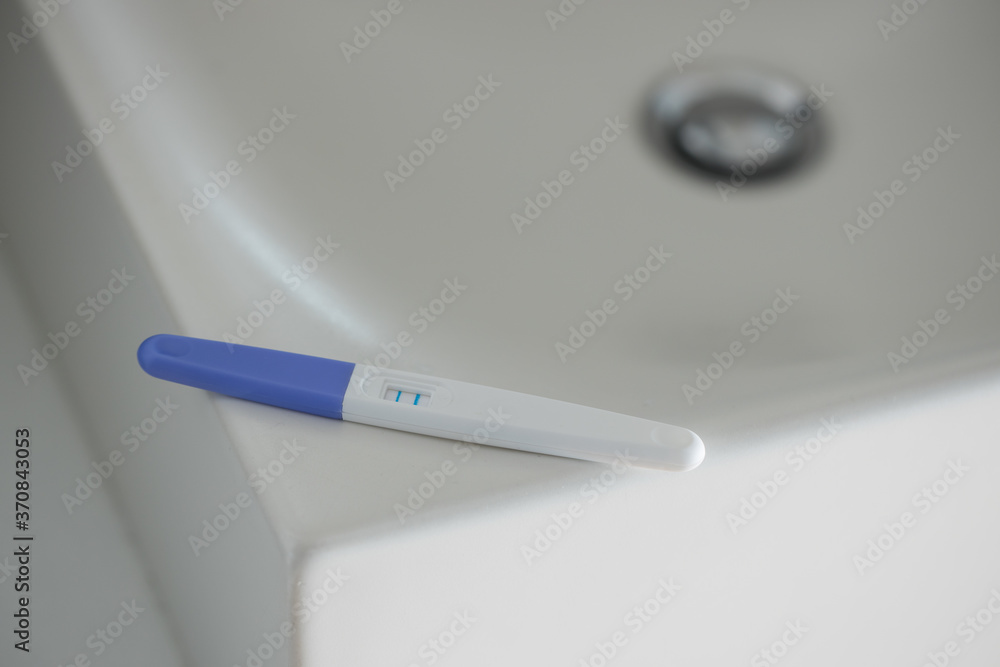 From above of pregnancy test with two bars for positive result placed ...