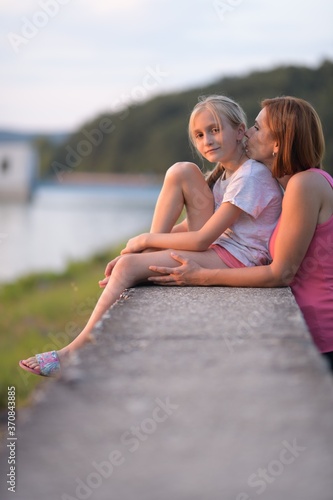 Portrait of a young woman embracing a little girl