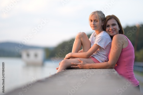 Portrait of a young woman embracing a little girl