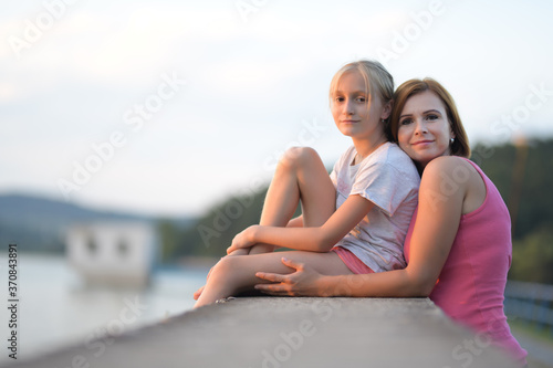 Portrait of a young woman embracing a little girl © muro