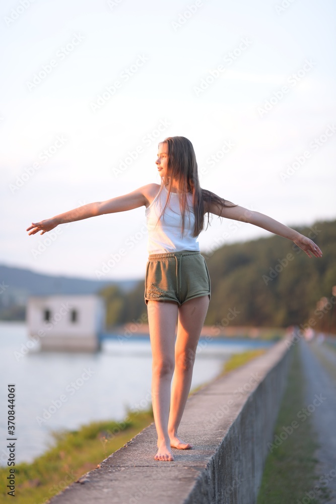 utdoor portrait of blond Caucasian teenage girl standing on a seacoast