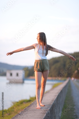 utdoor portrait of blond Caucasian teenage girl standing on a seacoast